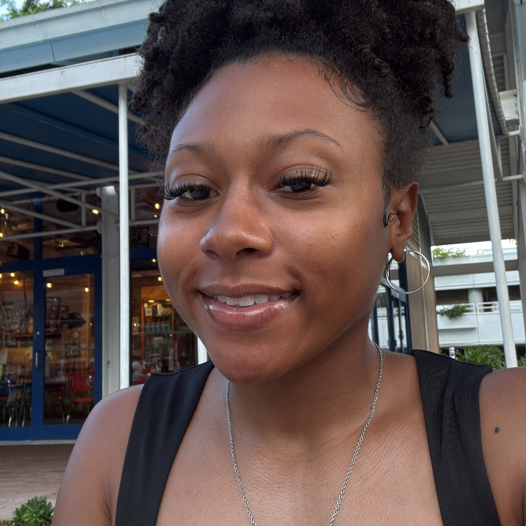 Jaryn posing for a photo in front of a white house. 