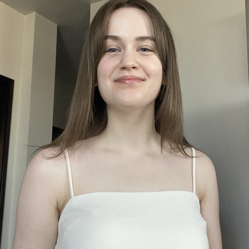 Mabel posing for a photo in a white top. 